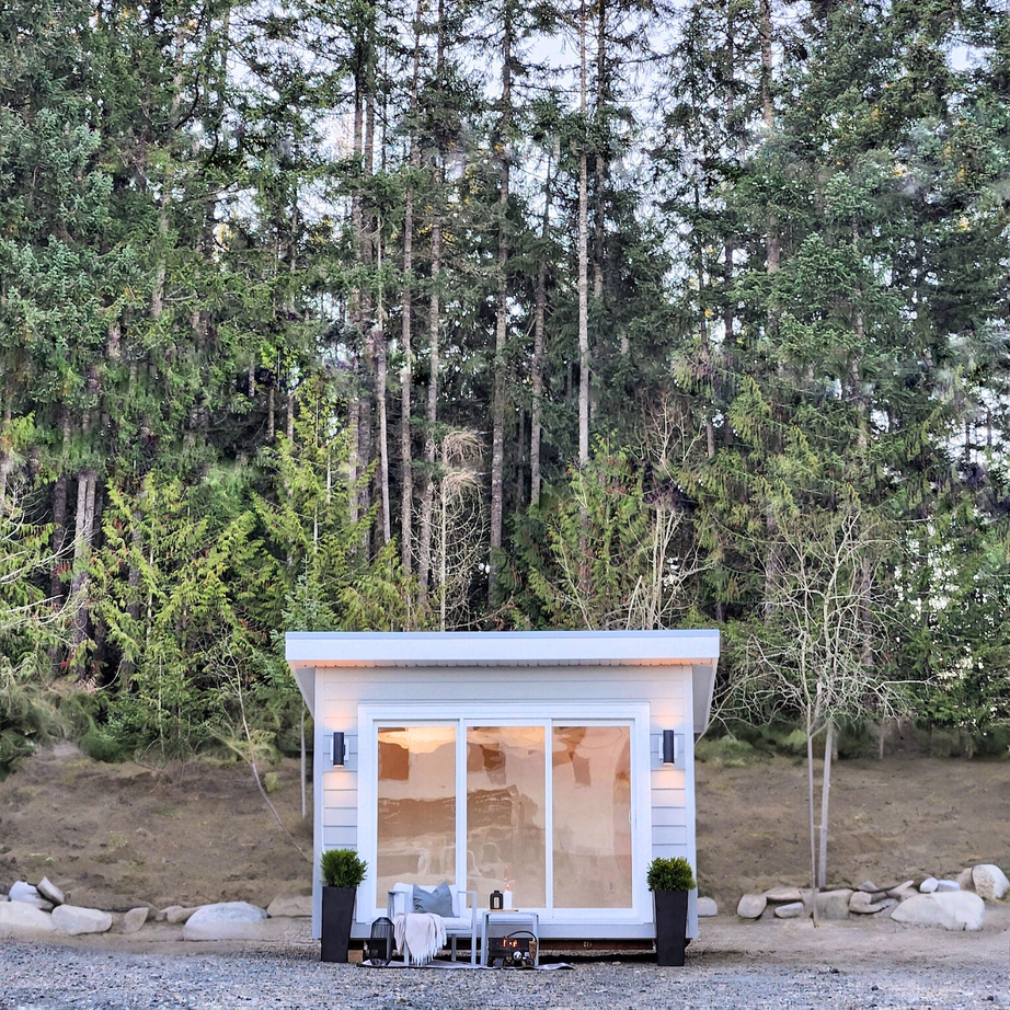 a tiny house sits in the middle of a forest