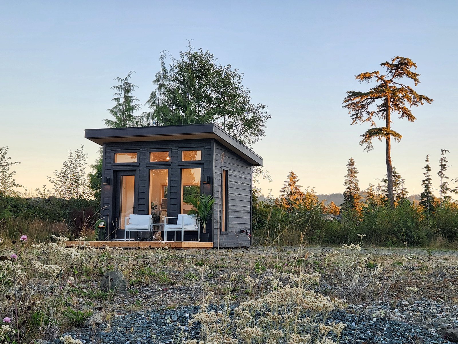 a tiny cabin sitting in the middle of a field